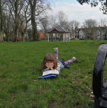 Young girl reading in the park