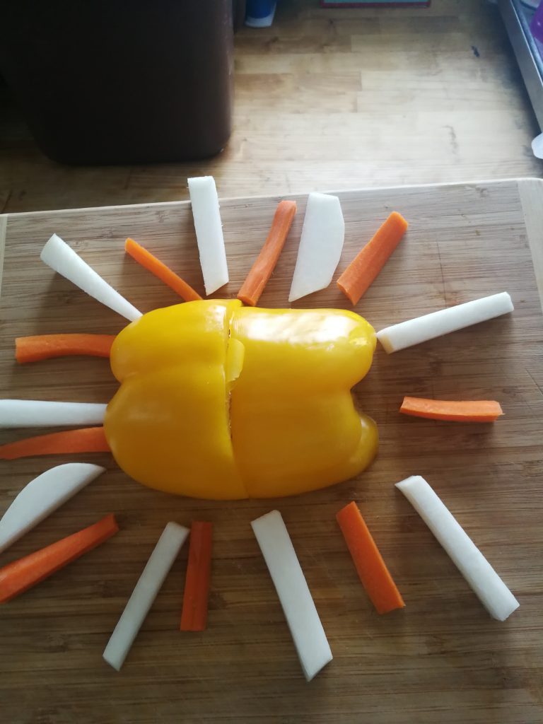 Representation of the sun made from yellow and orange peppers