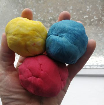 Someone holding three balls of homemade play dough